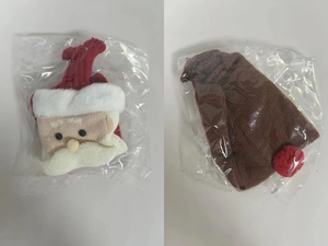 Nahaufnahme der gestrickten Weihnachtsmann-Weinflaschenhüllen in Klarsichtverpackung