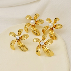 Close-up of gold flower earrings featuring elegant pearls and sparkling zircon accents