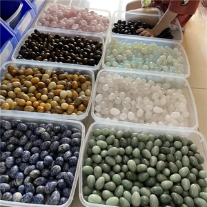 Batch of assorted 30mm egg-shaped natural crystal and agate stones in storage box
