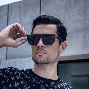 Detail of matte black oversized square sunglasses with silver arrow hinge on male model