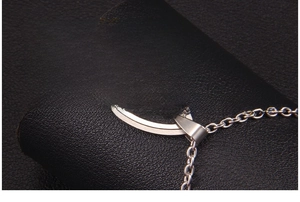 Macro shot of silver stainless steel Ichthys fish pendant with Jesus engraving and cross chain