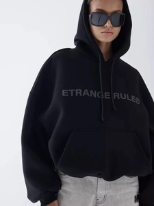 Oversized black hoodie with embossed lettering on chest, streetwear fashion style
