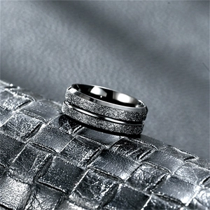Detail macro of matte black titanium steel ring on woven leather texture background