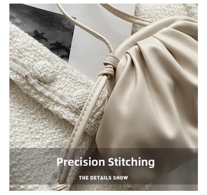 Macro detail of fine stitching and soft pleated texture on cream faux leather cloud bag