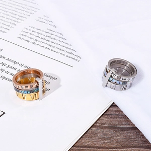 Macro shot of three-tone titanium steel rings with Roman numerals and shell inlay detail