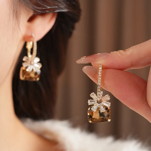 Dettaglio orecchini placcati oro 18k con gemma rettangolare ambra e fiori in zircone