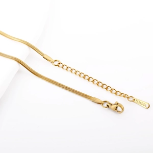 Macro detail of gold-plated stainless steel snake chain with lobster clasp and extender