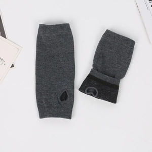 Macro detail of dark grey knitted fingerless arm sleeves with thumb hole and black trim