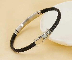 Detail eines geflochtenen Lederarmbands mit hohler Edelstahlplatte und poliertem Finish