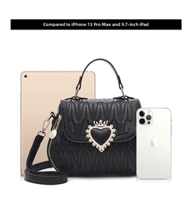 Close-up of quilted black bucket bag with golden heart buckle showing its capacity
