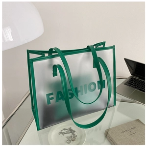 Detailed macro view of the lime green leather handles on the semi-transparent tote bag