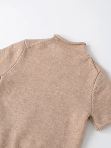 Detail of oat beige mock neck knit top showing fine stitching and soft wool texture