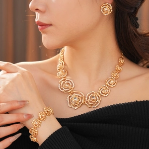 Elegant gold flower jewelry set with sparkling rhinestones on model with black top
