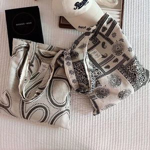 Detailed view of canvas tote bags with ethnic paisley patterns on white quilted fabric