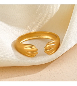 Vue détaillée d'une bague ouverte griffe de chat dorée sur du satin blanc