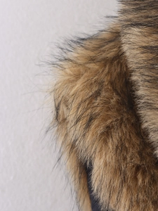 Detailopname van de dichte textuur van een kunstbontvest in bruin en zwart