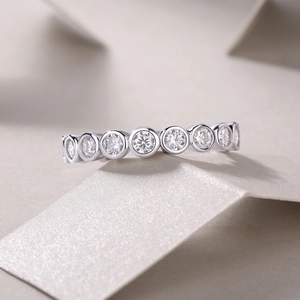 Detailed close-up of a S925 silver moissanite eternity ring with bezel set round stones