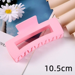Pink matte rectangular hair claw clip detail shot, showing frosted texture and geometric design.