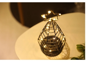 Close-up of star-topped metal cage LED Christmas tree lamp with warm fairy lights inside