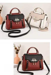 Detail of trendy crossbody bags with swan metal buckles, pearl tassels and litchi texture