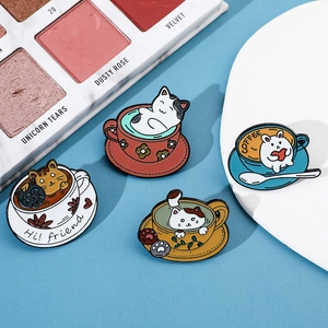 Detail of four creative cartoon cat and rabbit enamel pins on a blue background