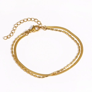 Détail d'un bracelet doré double couche avec chaîne serpent plate et billes