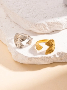 Macro shot of gold and silver leaf rings with detailed textures on stone surface