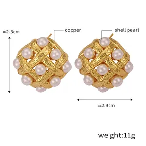 Detail of vintage square woven gold earrings featuring white shell pearls and hollow patterns