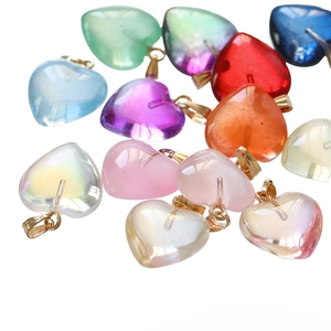 Detailed view of colorful translucent resin heart pendants with gold hooks on white background
