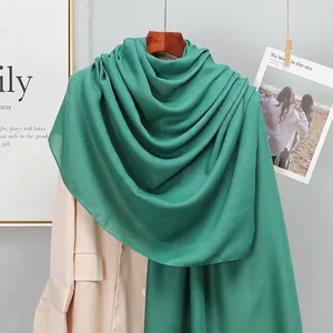 Detailed close-up of dark green linen scarf showing soft fabric texture and drape