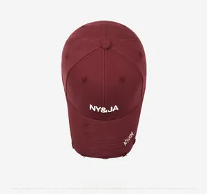 Detailed close-up of burgundy baseball cap with vintage distressed brim and NY&JA embroidery