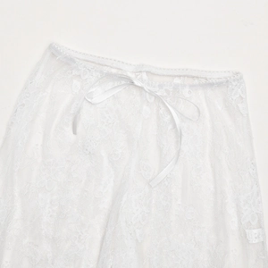 Detailed close-up of white floral lace texture and ribbon bow on waistline pants