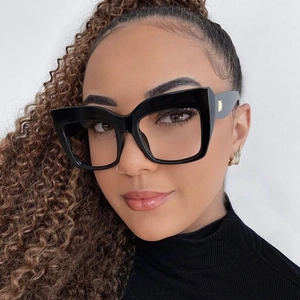 Detail of square oversized glasses with thick black frames and metallic hinge accents
