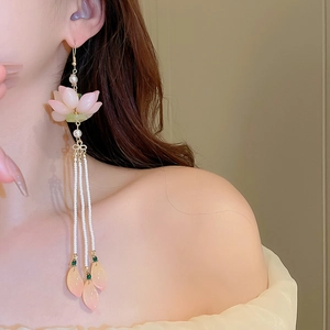 Detailed close-up of long tassel earrings with pink lotus flower and white seed pearls