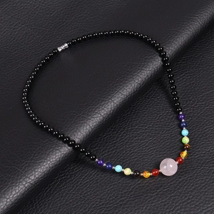 Detailed view of planetary beaded necklace with rose quartz and tiger eye on black leather