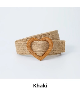 Detail of khaki woven straw belt featuring a stylish heart-shaped buckle for dresses