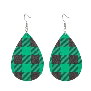 Close-up of teardrop earrings featuring a green and black checkerboard leather texture