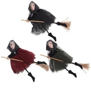 Three Halloween witch dolls in black, red and green linen dresses on wooden brooms