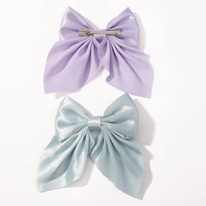 Detail of purple and light blue satin bow hair clips with metal alligator grip