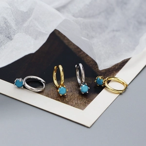 Detail of gold and silver S925 sterling silver hoop earrings with blue turquoise stones
