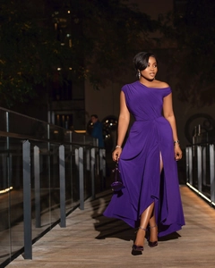 Detail of purple one-shoulder evening gown with high slit and elegant waist draping