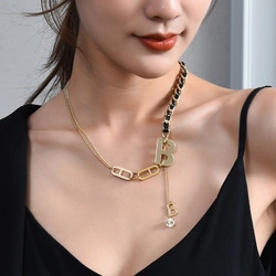 Detail of gold B-pendant necklace with interwoven black leather and metal chain