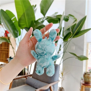 Detail of light blue plush bunny keychain with geometric shiny patchwork and silver chain