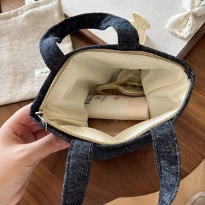 Internal view of small denim tote bag showing zipper closure and spacious capacity