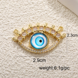 Detailed view of evil eye charm with gold plating and pink crystal, 2.9cm wide