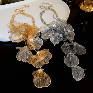 Detail of metal mesh flower necklaces in gold and silver with elegant tassel layers