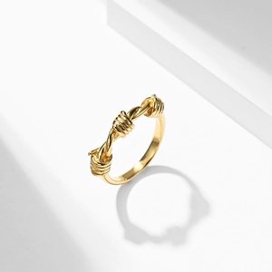 Minimalist gold knot barbed wire ring in stainless steel with sharp industrial aesthetic
