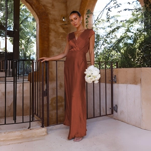 Detail of elegant copper satin evening gown featuring a deep V-neck and silky texture
