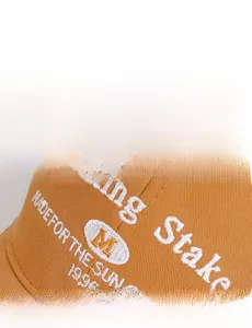 Detailed close-up of white towel embroidery letters on orange cotton baseball cap