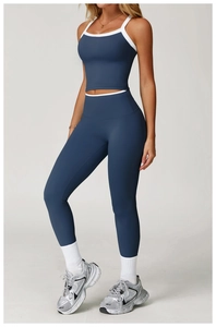 Detail van de yoga-legging met hoge taille en crop top met witte contrastbiezen